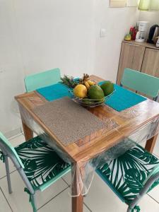 Una mesa de madera con un bol de fruta encima. en villa Rony, en Port-Louis