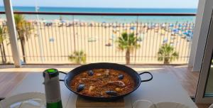 a pan of food on a table next to a beach at Levante Frontline Luxury Duplex 5 Bedrooms in Benidorm
