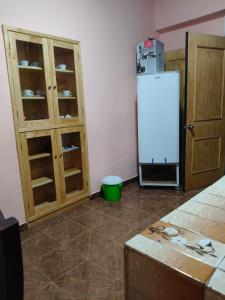 a kitchen with a white refrigerator and wooden cabinets at Hospedaje Santa Rita in Zacatlán