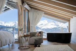 ein Schlafzimmer mit Badewanne und Bett mit Bergblick in der Unterkunft JAMES TAMG31 - luxury design chalet Megeve in Combloux