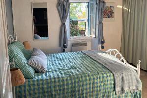a bedroom with a bed with a blue comforter and a window at 2 Bedroom Cottage - Sleeps 6 - Pool - Garden in Caylus +4 photos