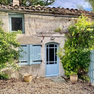 a house with a blue door and two windows at 2 Bedroom Cottage - Sleeps 6 - Pool - Garden in Caylus