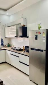 a kitchen with a refrigerator and white cabinets at Private Room in Peaceful Flat Attached Washroom in Kharar