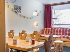 a room with a table and chairs and a couch at Appartement 6 personnes au centre, balcon, parking, Wifi - FR-1-346-470 in Arc 1800