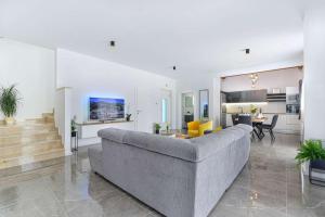 a living room with a couch and a dining room at Luxury Stone Villa BANOVI with heated pool in Vinjerac