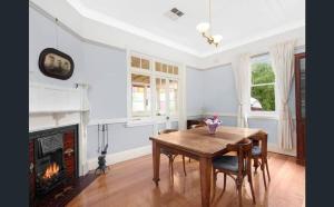 a dining room with a table and a fireplace at Haberfield House in Sydney