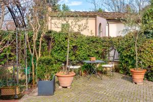 a patio with potted plants and a table and a wall at Pretty Suite Firenze Fiesole in Florence