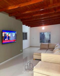 ein Wohnzimmer mit Couch und Flachbildfernseher in der Unterkunft Finca el Zanjón Punto Alquileres in Santiago del Estero