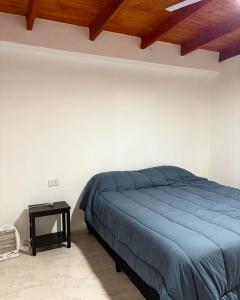 ein Schlafzimmer mit einem blauen Bett und einem Tisch in der Unterkunft Finca el Zanjón Punto Alquileres in Santiago del Estero + 12 Fotos