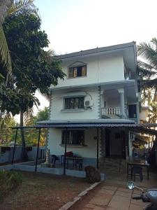 a white house with a balcony on top of it at Morni Home's morjim in Morjim