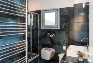 a bathroom with a toilet and a sink and a window at Villa Allegra in Kythira +38 photos