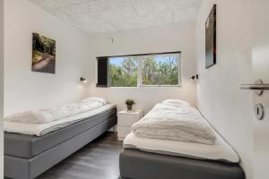 a room with two beds and a window at Hedevang 22 Houstrup in Nørre Nebel
