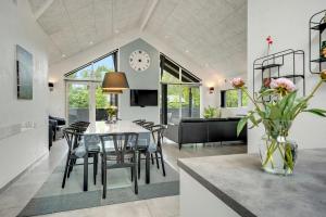 a dining room and living room with a table and chairs at Hedevang 22 Houstrup in Nørre Nebel