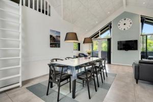 a dining room with a table and chairs and a clock at Hedevang 22 Houstrup in Nørre Nebel