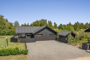 a house with a black garage and a driveway at Hedevang 22 Houstrup in Nørre Nebel