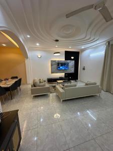 a living room with couches and a flat screen tv at Résidence Bonheur in Ouagadougou