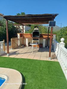 a patio with a grill and a table and a chair at Cortijo del carmen in Moratalla