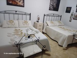 a bedroom with two beds and a dresser and a bedskirts at Cortijo del carmen in Moratalla