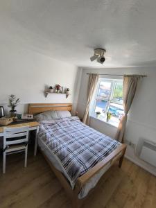 a bedroom with a bed and a desk and a window at Angelo's home in London