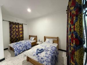 a room with two beds and a window at Mlangoni Cottages in Sanya Juu