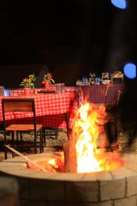a fire pit in front of a table with chairs at Mlangoni Cottages in Sanya Juu