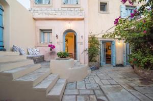 a courtyard of a building with stairs and flowers at Villa Allegra in Kythira