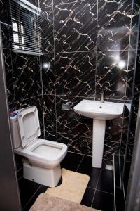 a bathroom with a white toilet and a sink at WHITNEY LUXURY APARTMENTs in Lekki