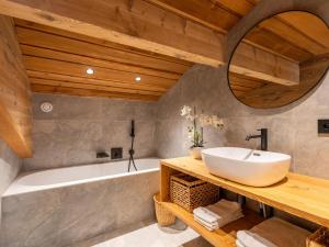 un bagno con lavandino e vasca da bagno di Chalet 8 pers avec SPA, proche pistes, rénové, WIFI, garage - FR-1-304-285 a La Clusaz
