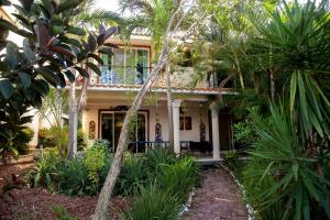 Spacious and elegant vacation home for 6 people in a private condominium في بلايا ديل كارمن: منزل أمامه أشجار نخيل