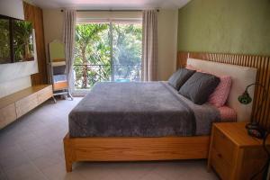 Spacious and elegant vacation home for 6 people in a private condominium في بلايا ديل كارمن: غرفة نوم بها سرير ونافذة كبيرة +36 صورة