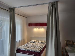 a bedroom with a bed with a curtain and a window at Apartament z tarasem ogrodowym in Łódź
