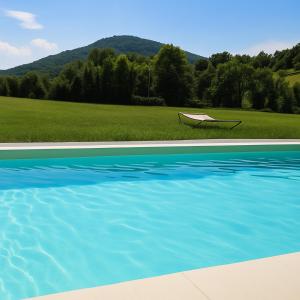 una silla sentada junto a una piscina de agua en Gîte cosy au calme dans l'enceinte du Domaine la Barre près de Mirepoix, en Dun