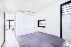 ein Schlafzimmer mit einem Bett in einem weißen Raum in der Unterkunft Hausboot "Fjordblik" in Barth in Barth