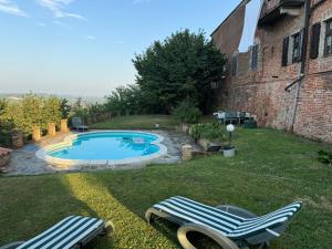 a yard with two lounge chairs and a swimming pool at Castello Stella in Vaglio Serra ,Monferrato unesco in Vaglio Serra