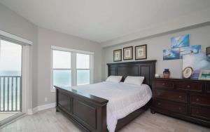 a bedroom with a large bed and a large window at Oceanfront Two Bedroom Condo with Panoramic Views in Neptune Beach