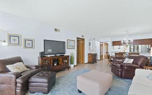 Il comprend un salon doté d'un mobilier en cuir et d'une télévision à écran plat. dans l'établissement Oceanfront Two Bedroom Condo with Balcony and Heated Pool, à Cocoa Beach