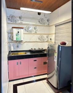 a kitchen with pink cabinets and a stainless steel refrigerator at The soul view homestay in Suryanelli +4 photos