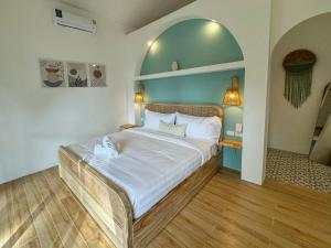 Un dormitorio con una cama grande con una pared azul. en Boho Village, en Ko Pha Ngan 80 fotos más