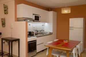 a kitchen with white cabinets and a table and a table and chairs at Centro Perú 2 in Paraná