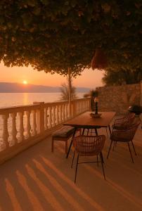 a table and chairs on a patio with the sunset at Villa ZeN- with Private garden and beach in Samos