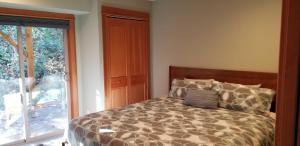 ein Schlafzimmer mit einem Bett und einem großen Fenster in der Unterkunft B2 Townhome with BBQ on the Deck in Hood River