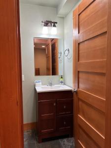 ein Badezimmer mit Waschbecken und Holztür in der Unterkunft B2 Townhome with BBQ on the Deck in Hood River + 16 Fotos