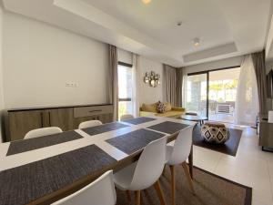 a dining room with a long table and white chairs at appartement alhoceima vip sfiha in Al Hoceïma