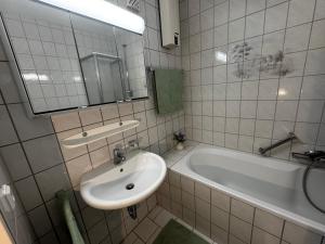 a bathroom with a sink and a tub and a mirror at Moderne Monteurwohnung in der Nähe vom VW Werk 1 in Wolfsburg