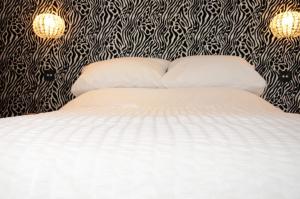 a bedroom with a bed with black and white wallpaper at Frankies Wine Bar & Lodge in Disley