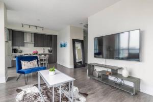 a living room with a large flat screen tv on a wall at Luxury 1BR Suite w Skyline City Views - The Roland in Toronto