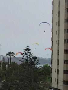 a group of kites flying in the sky near a building at Miraflores Moonlight in Lima