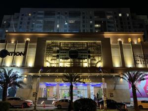 ラホールにあるGold Crest Presidential Family Apartments-DHA Lahore Phase 4の建物の前に車が駐車されている