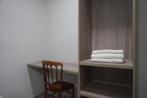 a room with a chair and a pile of towels at Hotel Portal dos Cerrados in Uruçuí +16 photos