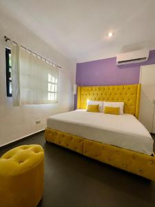 1 dormitorio con 1 cama grande y cabecero amarillo en Marisol Beach, en Playa del Carmen